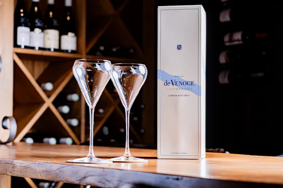 Deux flûtes à champagne devant un coffret de Venoge